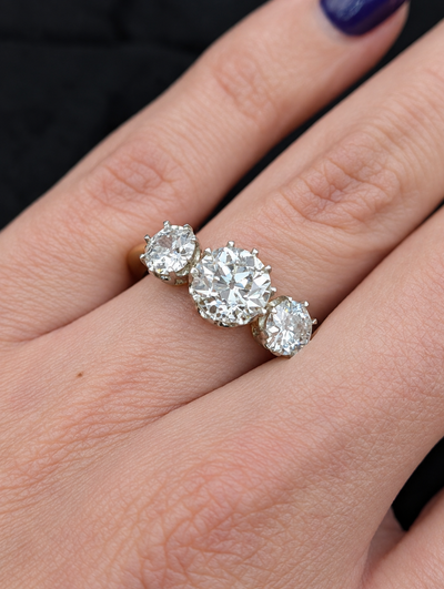 Close-up of the 3.05 carat three-stone old European cut diamond ring worn on the hand