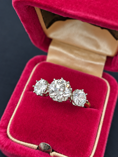 Front view of the three-stone diamond ring in a pink jewelry box