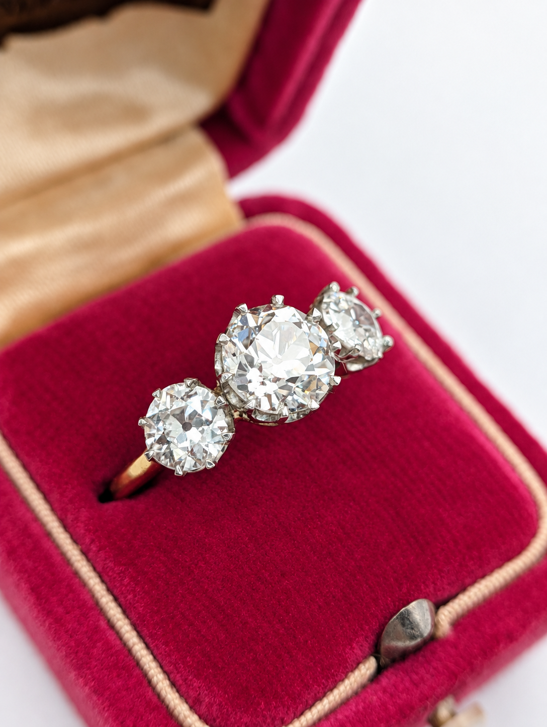 Angled view of the 3.05 carat three-stone diamond ring in a pink jewelry box