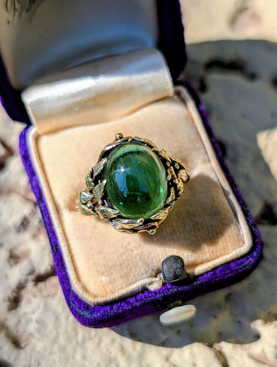 Front view of vintage green tourmaline cabochon ring in a 14k gold leaf-like mounting