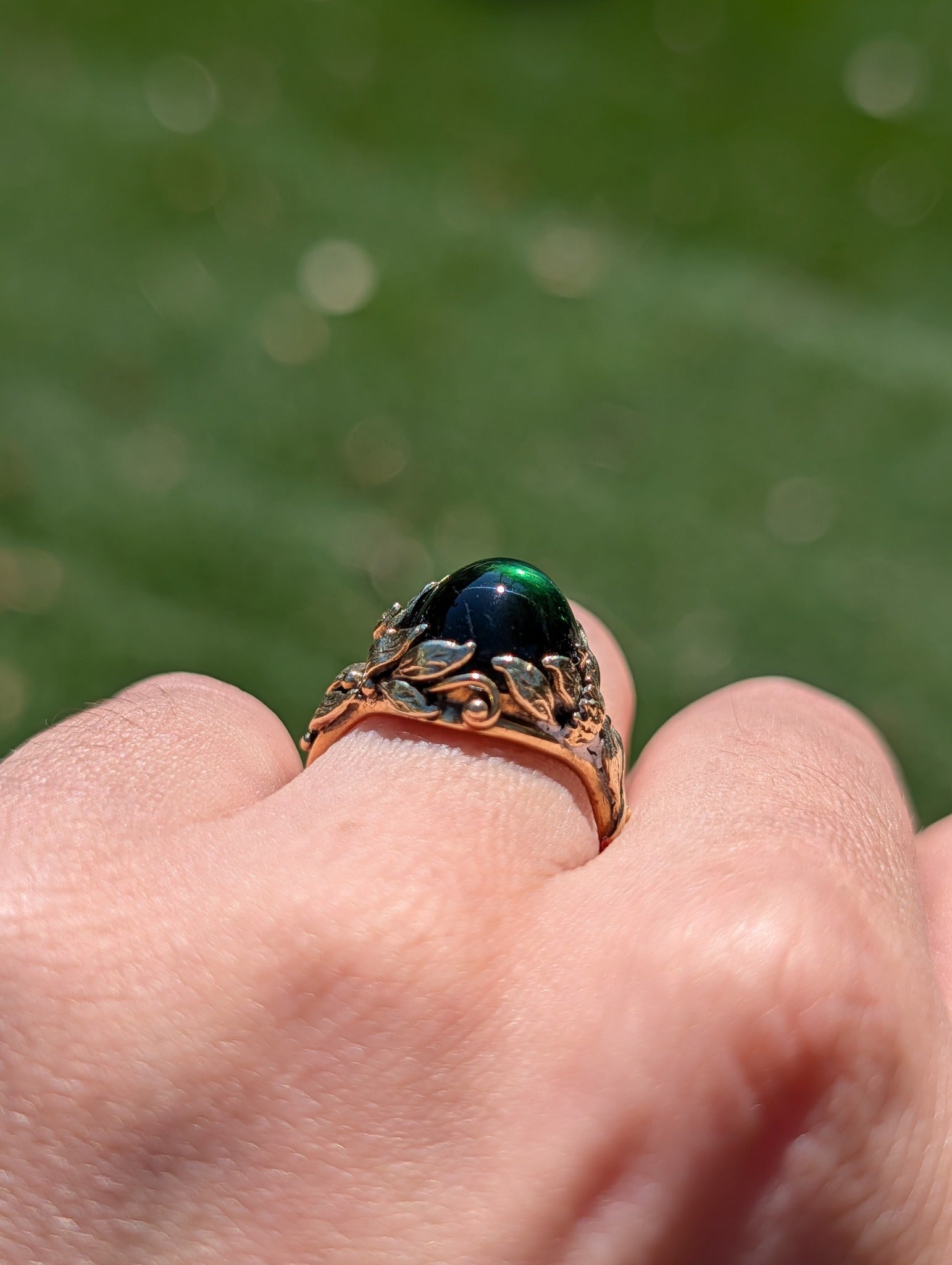 Profile of green tourmaline cabochon in its 14k gold mounting