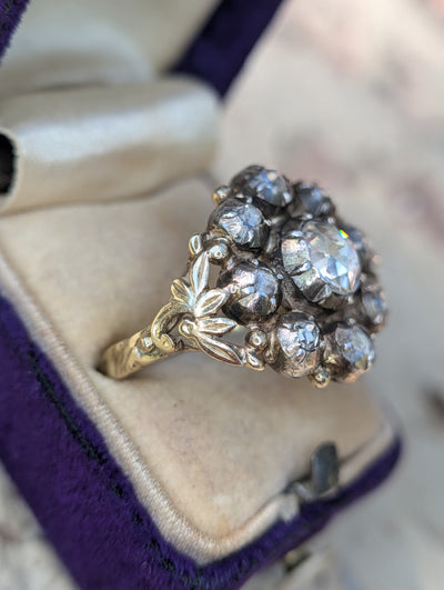 Angled box view showing the diamond cluster and leafy gold shoulder