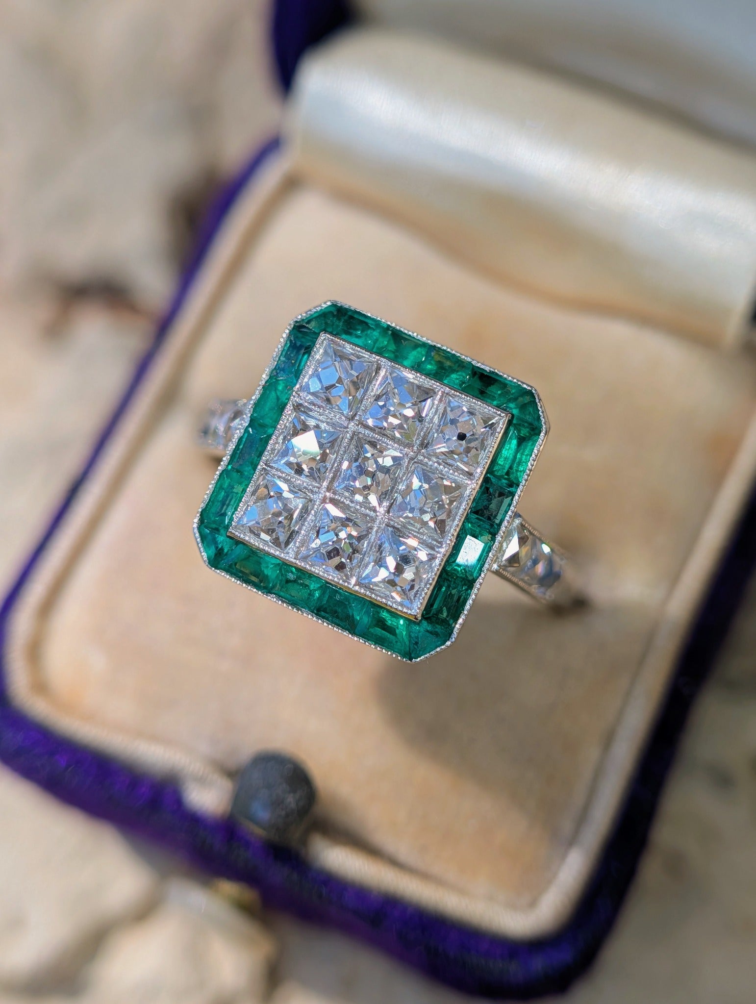 French-cut diamond and natural emerald ring in its ring box