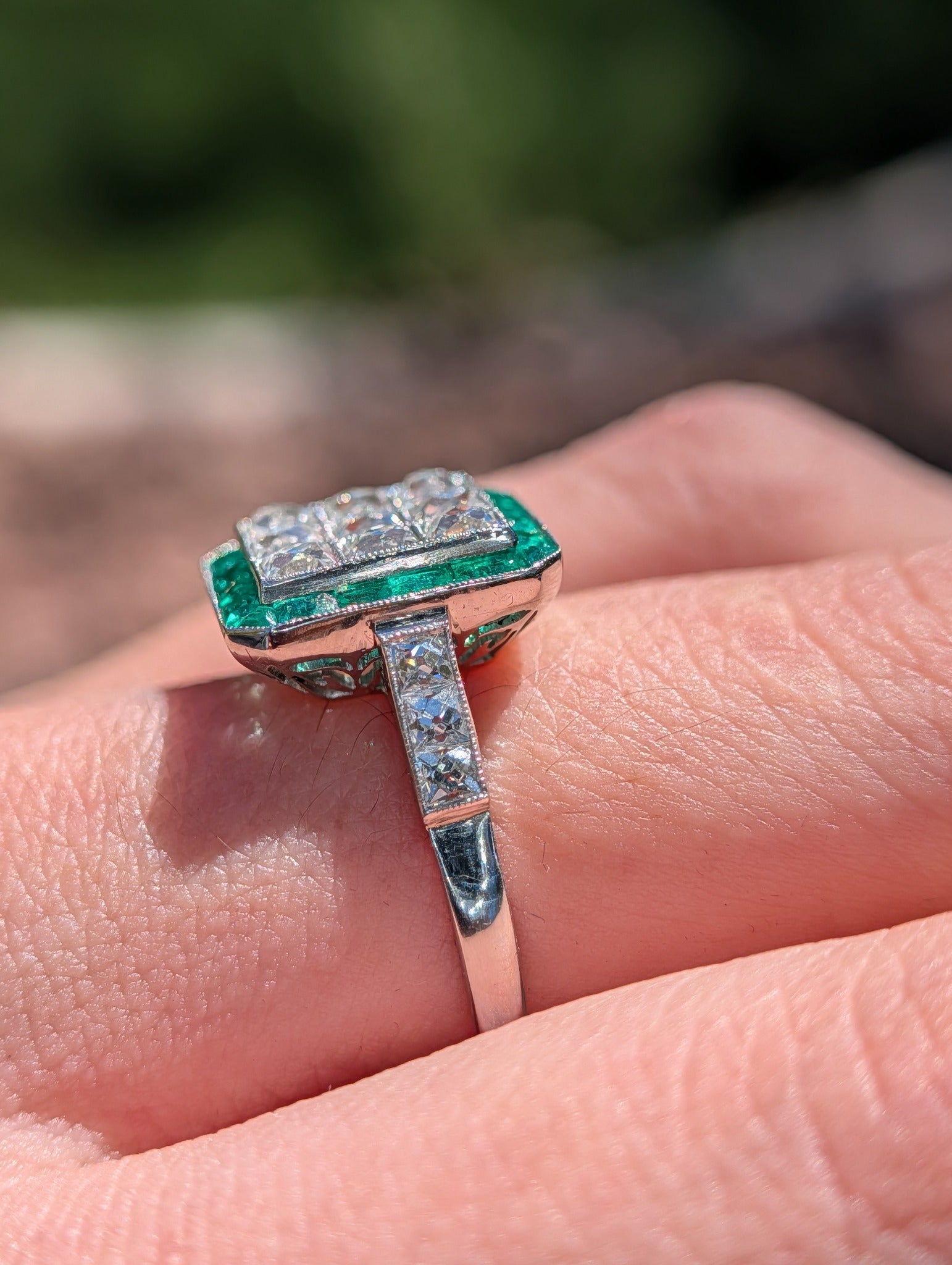 Side view showing diamond shoulders, milgrain edging, and pierced platinum gallery