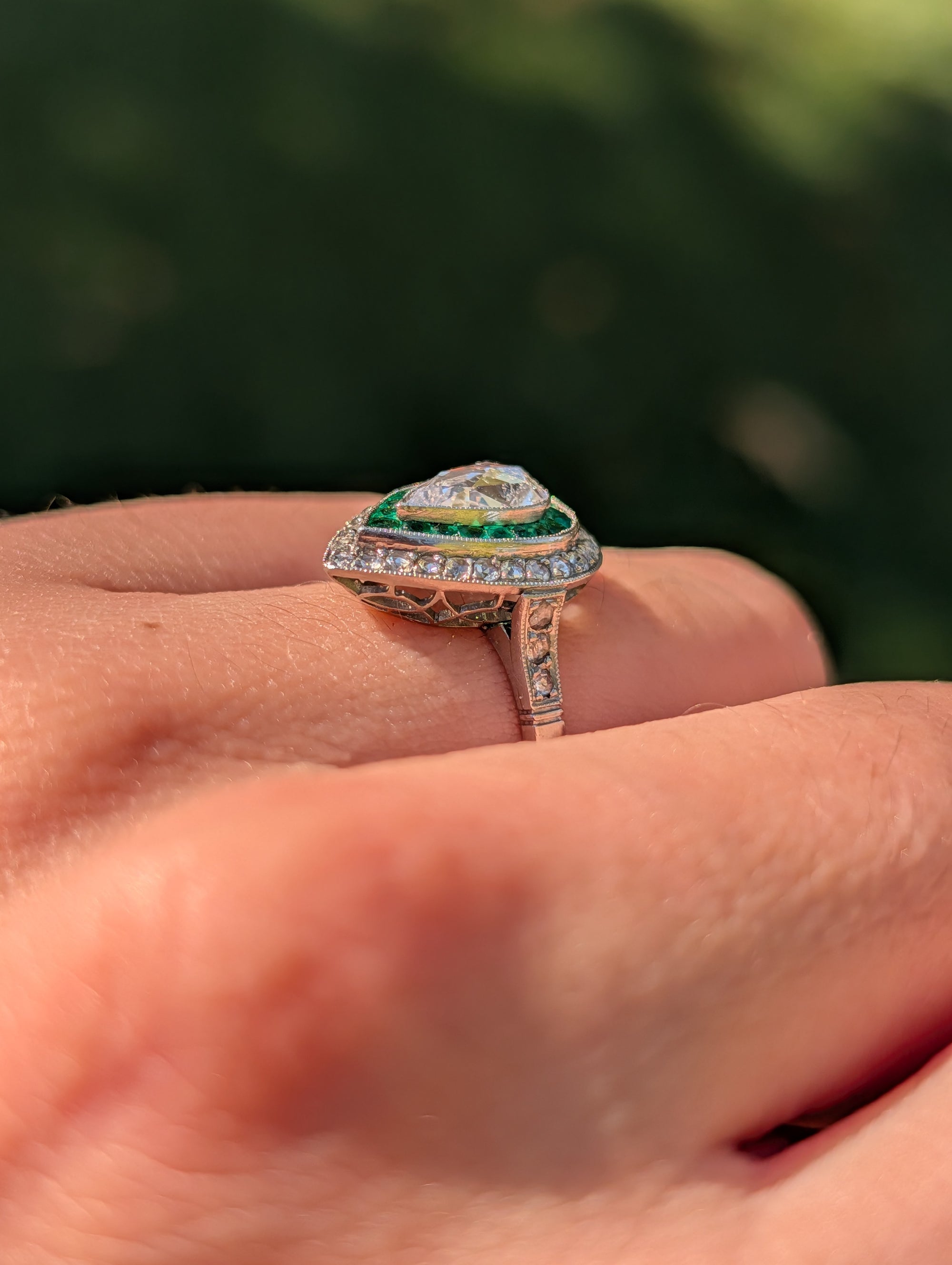 Pear rose-cut diamond and emerald platinum ring worn on the hand