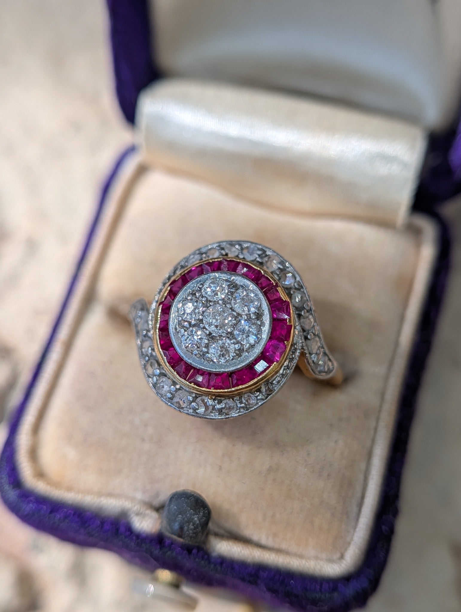 Front view of old European-cut diamond cluster, synthetic ruby border and rose-cut diamond tourbillon ring