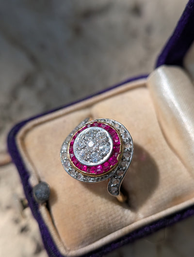 Close view of diamond cluster and synthetic ruby border in 18k gold and platinum