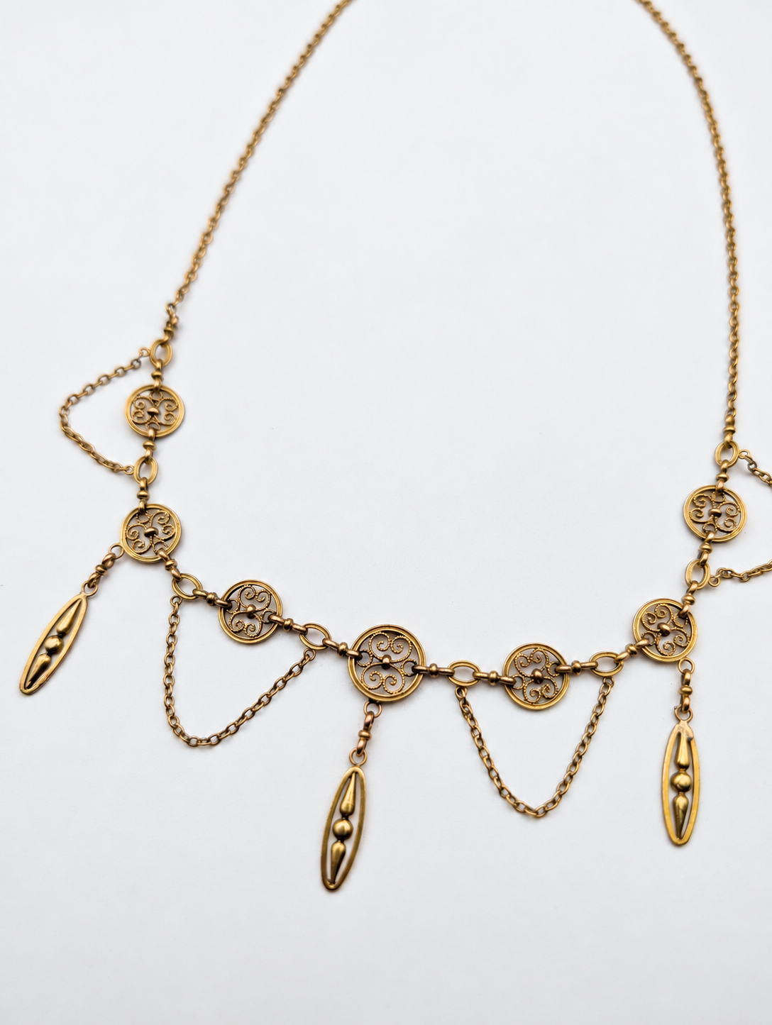 French 18K gold festoon necklace on a white background