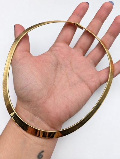 Italian 18K gold omega collar — held in hand