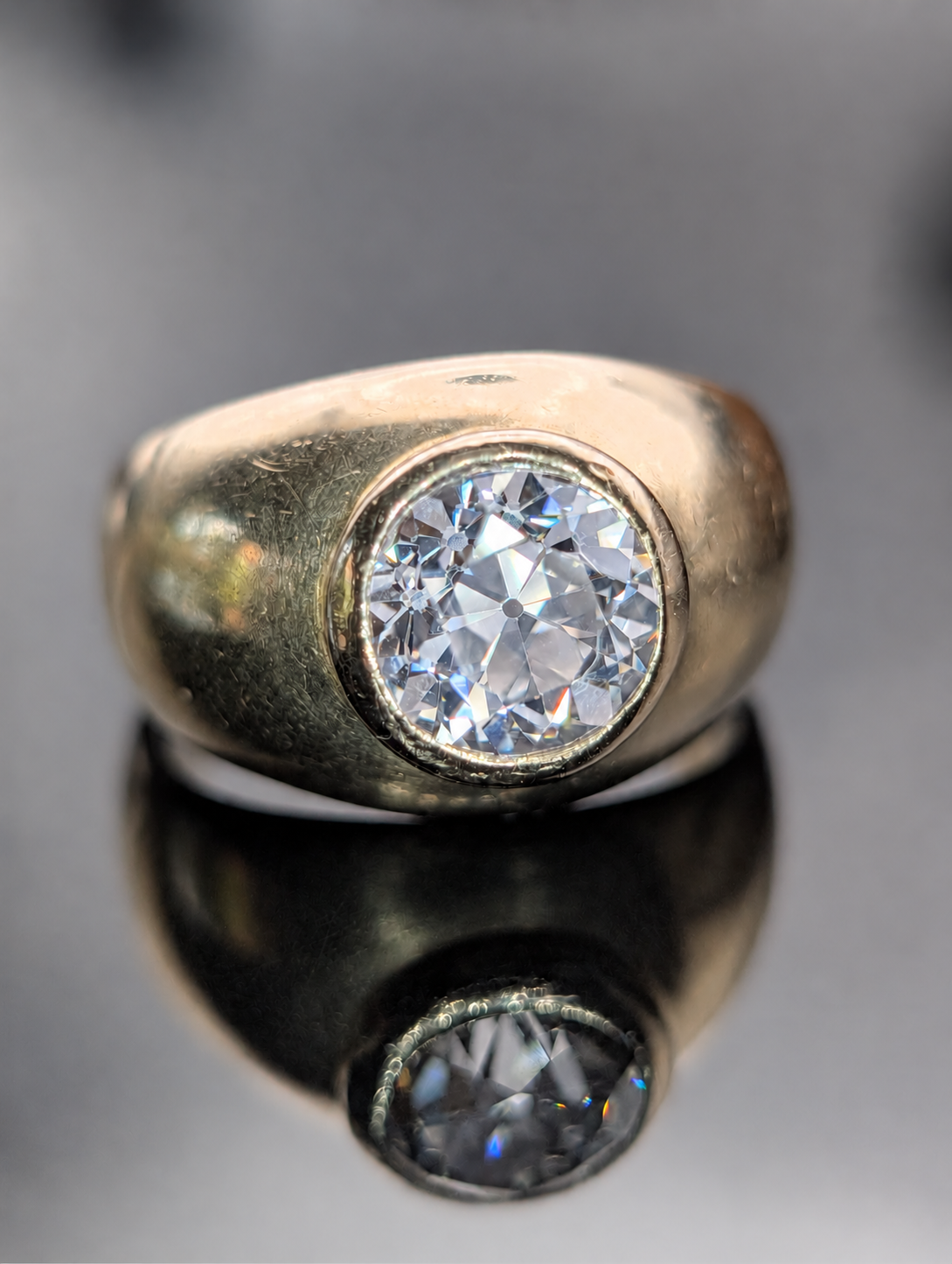 Vintage 18 karat gold bezel ring with old European cut diamond, photographed with its reflection